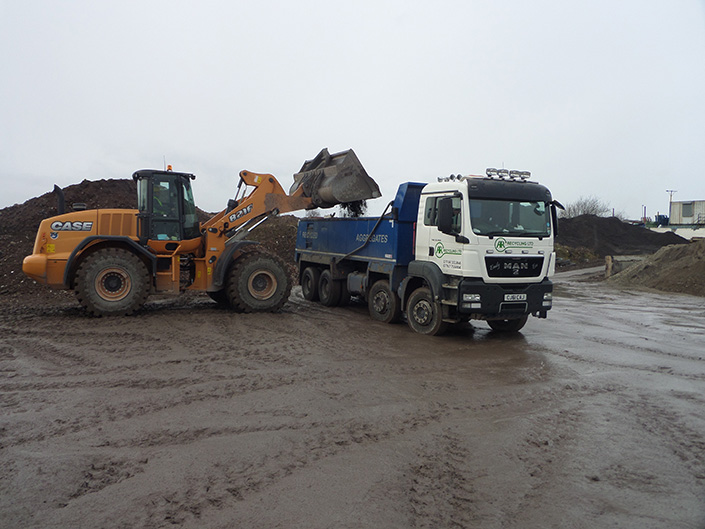 Lorry being loaded by a digger.